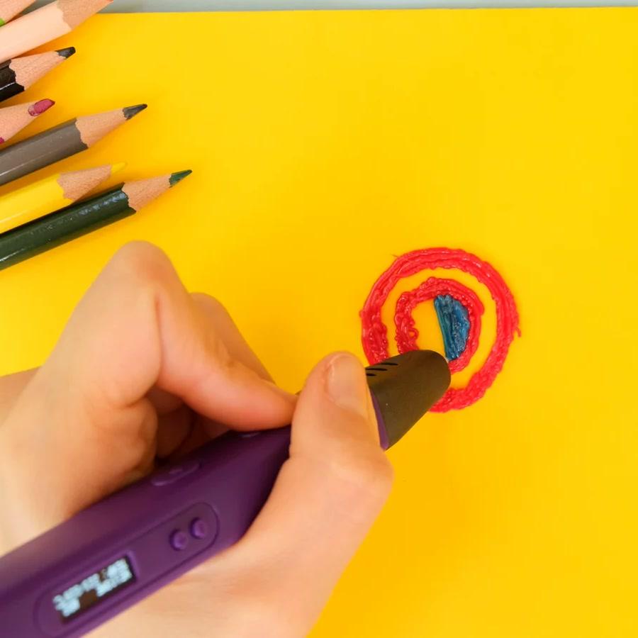 Hand tracing a colored shape with a 3D pen