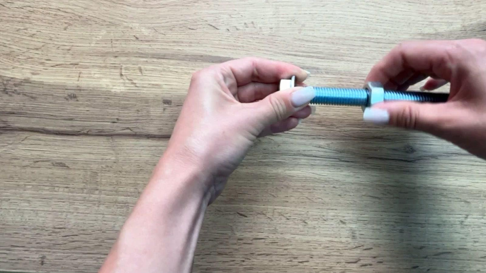 Hands manipulating a bolt and nut