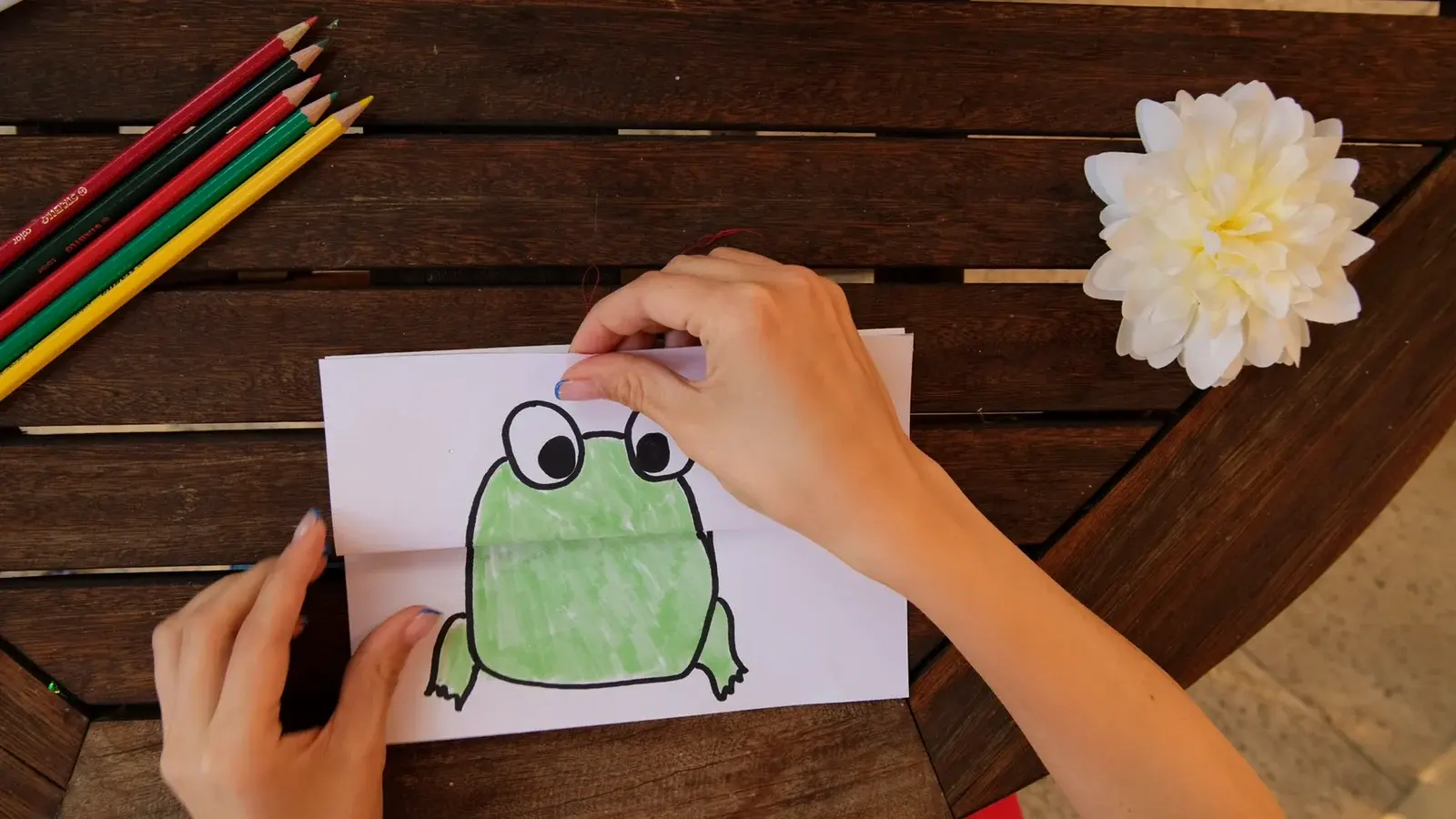 Hands arranging a drawn character element from the Creative Hands sample